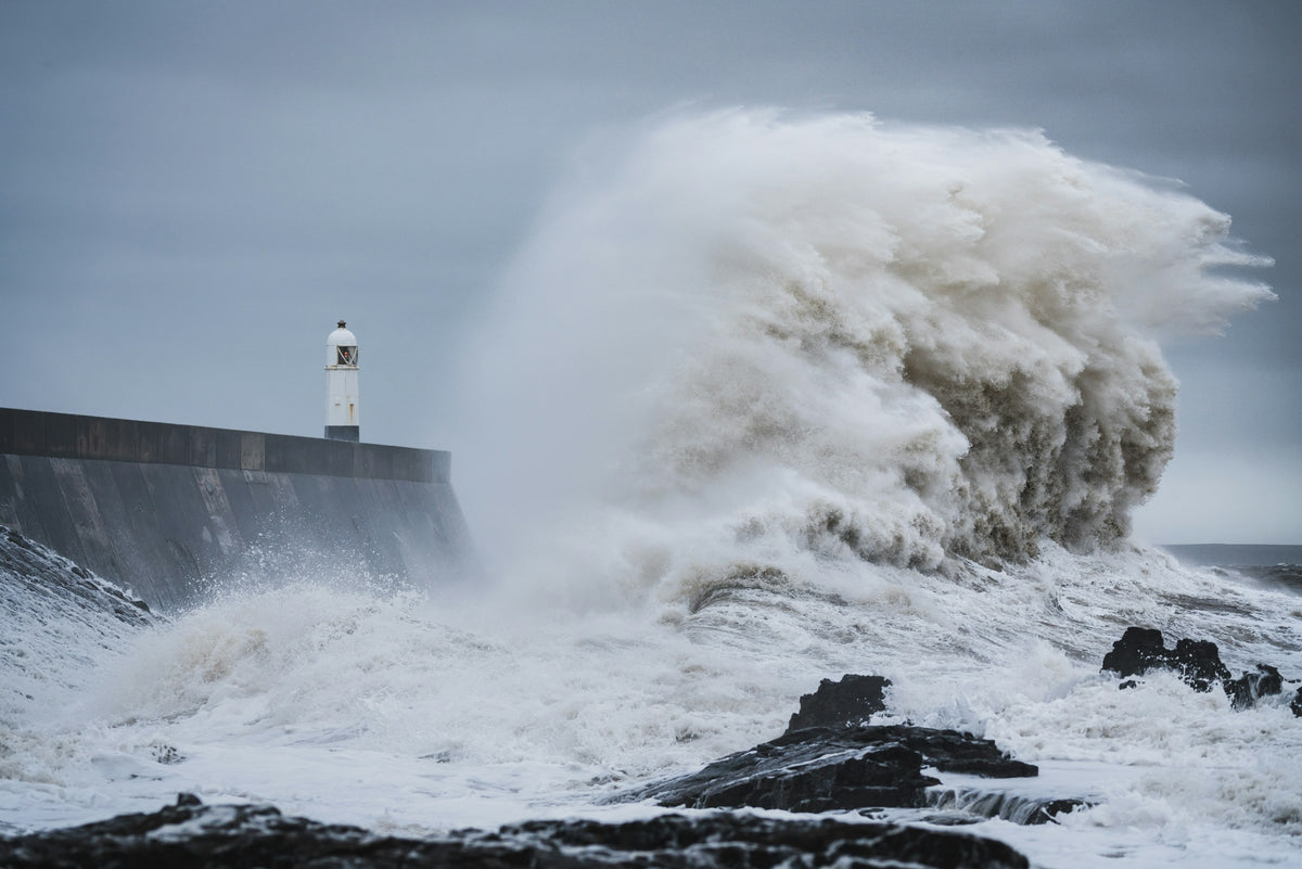 A huge storm wave crashing over Porthcawl lighthouse in Wales